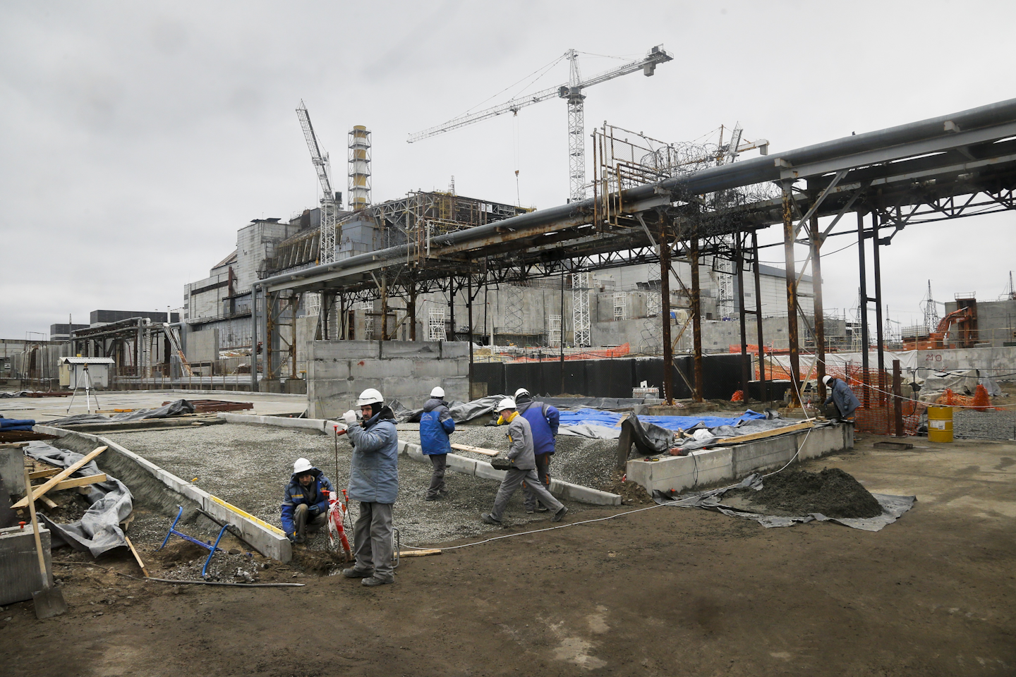 In this photo taken March 23, 2016, constructors work close to the old sarcophagus, in the background, at the Chernobyl nuclear power plant in Chernobyl, Ukraine. Thirty years after the world’s worst nuclear accident, the Chernobyl nuclear power plant is surrounded by both a hushed desolation and clangorous activity, the sense of a ruined past and a difficult future. (AP Photo/Efrem Lukatsky)