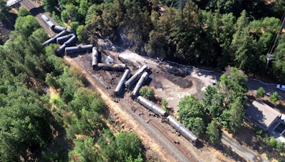 This aerial view provided by the Washington State Department of Ecology shows scattered and burned oil tank cars, Saturday, June 4, 2016, after the train derailed and burned near Mosier, Ore., Friday. Union Pacific Railroad says it had recently inspected the section of track near Mosier, about 70 miles east of Portland, and had been inspected at least six times since March 21. (Washington Department of Ecology via AP)