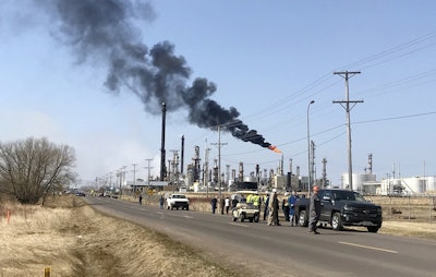 This photo provided by KQDS_FOX21 in Duluth, Minn., shows vehicles and personnel outside the Husky Energy oil refinery Thursday morning, April 26, 2018, after a tank containing crude oil or asphalt exploded at the large refinery in Superior, Wis. Image credit: Natalie Froistad/KQDS_FOX21 via AP