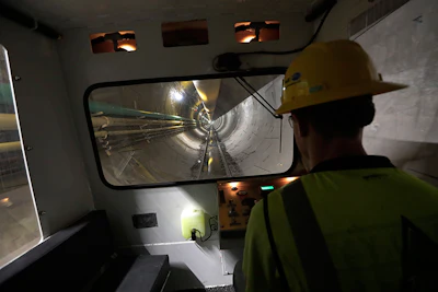 In this Wednesday, May 16, 2018 photo, operator Andrew Reisinger drives a personnel shuttle along a small gauge rail line inside a 2.5-mile bypass tunnel being dug for the Delaware Aqueduct, in Marlboro, NY. (AP Photo/Julie Jacobson)