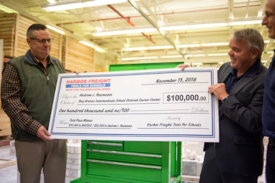 Andrew J. Neumann, left, accepts a $100,000 check from Scott Springer with Harbor Freight Tools for Schools, right, at Bay Arenac Intermediate School District Career Center in Bay City, Michigan Thursday, November 15, 2018. The $100,000 was awarded to Neumann and Bay Arenac Career Center as one of the first-place winners of the 2018 Harbor Freight Tools for Schools Prize for Teaching Excellence, part of $1 million awarded nationally by Harbor Freight Tools for Schools. Neumann is a building trades teacher whose students are building a house from the ground up.