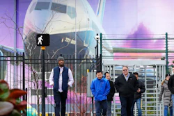 Boeing workers exit the plant in front of a giant mural of a jet on the side of the manufacturing building behind Monday, Dec. 16, 2019, in Renton, Wash. Shares of Boeing fell before the opening bell on a report that the company may cut production of its troubled 737 MAX or even end production all together.