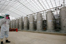 In this Nov. 12, 2014, file photo, a Tokyo Electric Power Co. (TEPCO) official wearing a radioactive protective gear stands in front of Advanced Liquid Processing Systems during a press tour at the Fukushima Dai-ichi nuclear power plant in Okuma, Fukushima Prefecture, northeastern Japan. Japan's economy and industry ministry has proposed gradually releasing or allowing to evaporate massive amounts of treated but still radioactive water at the tsunami-wrecked Fukushima nuclear plant. The proposal made Monday, Dec. 23, 2019, to a body of experts is the first time the ministry has narrowed down the options available to just releasing the water.