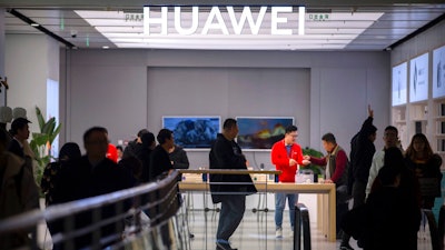 In this Nov. 20, 2019, photo, customers shop at a Huawei store at a shopping mall in Beijing. The founder of Huawei says the Chinese tech giant is moving its U.S. research center to Canada due to American restrictions on its activities.