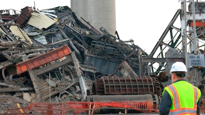 A person looks on as DTE Energy Co.'s old Conners Creek Power Plant is demolished Friday, Dec. 13, 2019, in Detroit. The power plant that was more than 100 years old was demolished Friday to accommodate a Jeep factory.