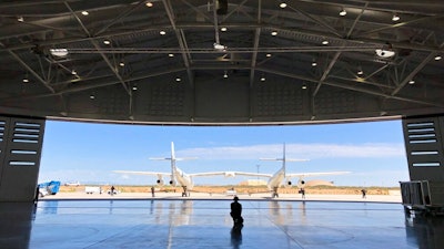 In this Aug. 15, 2019 file photo, Virgin Galactic ground crew guide the company's carrier plane into the hangar at Spaceport America following a test flight over the desert near Upham, New Mexico. Virgin Galactic is on the verge of making more history in 2020 following an 'incredible' year of progress, the chief executive of billionaire Richard Branson's space tourism venture said Thursday.