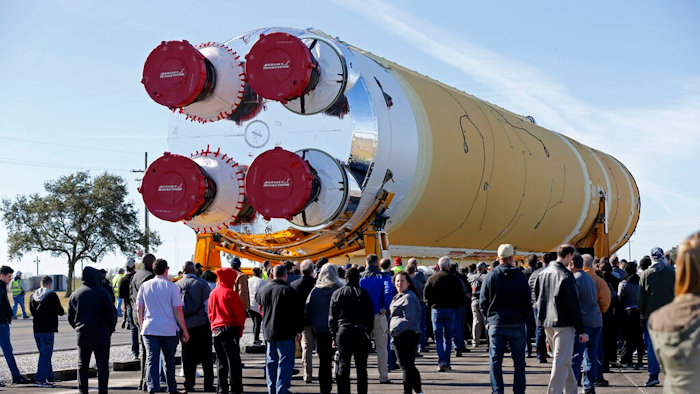 Employees and contractors watch as the core stage of NASA's Space Launch System rocket, that will be used for the Artemis 1 Mission, is moved to the Pegasus barge, at the NASA Michoud Assembly Facility where it was built, in New Orleans, Wednesday, Jan. 8, 2020. It will be transported to NASA's Stennis Space Center in Mississippi for its green run test.