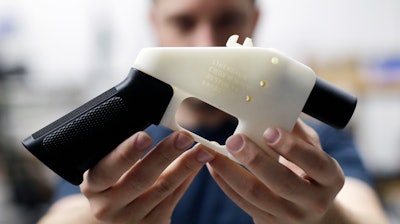 In this Aug. 1, 2018 file photo, Cody Wilson, with Defense Distributed, holds a 3D-printed gun called the Liberator at his shop in Austin, TX.