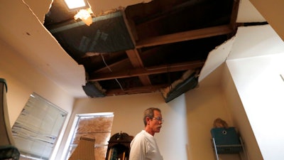 Kent Heap stands with a crumbling ceiling inside of his sister, Carol Goff's home, as people continued to sift through their damaged homes on Bridgeland Lane in Houston, Sunday, Jan. 26, 2020, after the Watson Grinding Manufacturing explosion early Friday morning.
