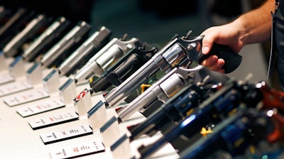 In this Jan. 19, 2016, file photo, handguns are displayed at the Smith & Wesson booth at the Shooting, Hunting and Outdoor Trade Show in Las Vegas. The gun industry is gathering for its annual conference, in January 2020, amid a host of uncertainty: slumping gun sales, a public increasingly agitating for restrictions on access to firearms and a presidential campaign that threatens gun rights like perhaps no other time in modern American history.