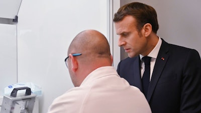 French President Emmanuel Macron speaks to an employee as he visits a plant of British-Swedish pharmaceutical group Astrazeneca in Dunkirk, northern France, Monday, Monday, Jan. 20, 2020. French President Emmanuel Macron is hosting 180 international business leaders later today at the Palace of Versailles in a bid to promote France's economic attractiveness despite over six weeks of crippling strikes over his government's planned pension changes.