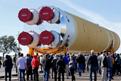 Employees and contractors watch as the core stage of NASA's Space Launch System rocket, that will be used for the Artemis 1 Mission, is moved to the Pegasus barge, at the NASA Michoud Assembly Facility where it was built, in New Orleans, Wednesday, Jan. 8, 2020. It will be transported to NASA's Stennis Space Center in Mississippi for its green run test.