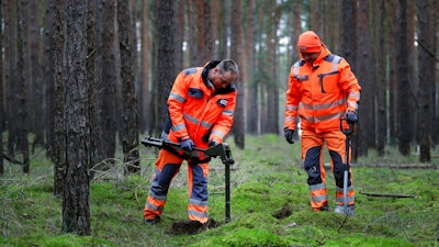 In this Wednesday, Jan. 8, 2020 photo members of a bomb disposal team search for WWII munition in Gruenheide near Berlin, Germany. Tesla CEO Elon Musk said during an awards ceremony in Berlin in November 2019 that 'we have decided to put the Tesla Gigafactory Europe in the Berlin area.' The company will also set up an engineering and design center in Berlin, Musk said. He wrote on Twitter that the new plant 'will build batteries, powertrains & vehicles, starting with Model Y.'