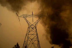 In this Nov. 9, 2018, file photo, smoke billows around power transmission lines as the Camp Fire burns in Big Bend, Calif. Pacific Gas & Electric Co., the nation's largest electric utility, filed for bankruptcy last year after facing an estimated $50 billion in damages from several Northern California wildfires that were linked to its equipment, including one blaze in 2018 that killed 85 people and destroyed about 19,000 buildings.