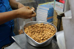 In this June 22, 2019 file photo, a shopkeeper weighs California almonds for a customer at a shop in New Delhi, India. Almonds used to have about 170 calories per serving, then researchers said it was really more like 130. A little later, they said the nuts may have even less. The shifting numbers for almonds show how the figures stamped on nutrition labels may not be as precise as they seem.