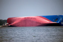 In this Sept. 9, 2019, file photo, a Moran tugboat nears the stern of the capsizing vessel Golden Ray near St. Simons Sound off the coast of Georgia.