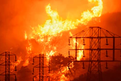 This Dec. 16, 2017 photo shows flames burning near power lines in Montecito, Calif.