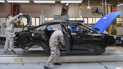 In this Feb. 17 file photo released by Xinhua News Agency, workers assemble Audi A6 L cars at a workshop of FAW-Volkswagen Automobile Co., Ltd. in Changchun, northeast China's Jilin Province.