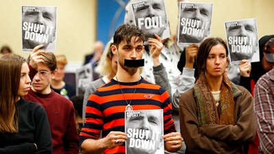 In this Jan. 8, 2019, file photo, protesters hold signs as they turn their backs on a meeting of the Virginia State Air Quality Control Board in Richmond, Va. The U.S. Supreme Court is set to wade into a long-running battle between developers of a 605-mile natural gas pipeline and environmental groups who oppose the pipeline crossing the storied Appalachian Trail. On Monday, Feb. 24, 2020, the high court will hear arguments on a critical permit needed by developers of the Atlantic Coast Pipeline.