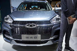 In this April 25, 2018, file photo a staff member stands next to a Tiggo 8 SUV by Chinese automaker Chery after a press conference at the China Auto Show in Beijing. A California company says it will build and sell Chinese-designed automobiles in the U.S. at the end of next year or early in 2022.