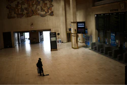 A man looks at train departures boards in a nearly empty Central station in Brussels, Wednesday, March 18, 2020.