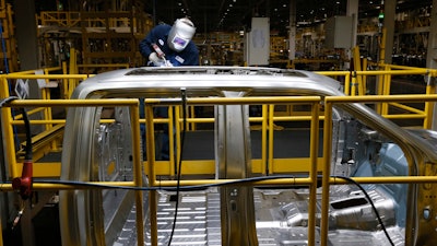 In this Nov. 11, 2014 photo, Ron Hudgins welds a 2015 Ford F-150 cab at the Dearborn Truck Plant in Dearborn, Mich.