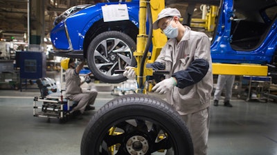 In this photo released by Xinhua News Agency, workers labor at an assembly line for Dongfeng Passenger Vehicle Company in Wuhan, in central China's Hubei Province, March 24, 2020.