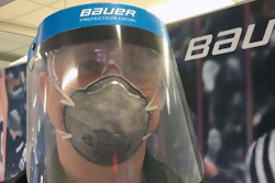 A Bauer Hockey employee models a medical face shield the hockey equipment manufacturer has begun creating to help those treating the coronavirus pandemic.