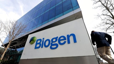 A man walks outside the Biogen Inc., headquarters, Wednesday, March 11, 2020, in Cambridge, Mass. Seventy of Massachusetts' first 92 confirmed coronavirus cases have been linked to a meeting of Biogen executives that was held at the Marriott Long Wharf hotel in Boston in late February 2020. For most people, the virus causes only mild or moderate symptoms, such as fever and cough. For some, especially older adults and people with existing health problems, it can cause more severe illness, including pneumonia. The vast majority of people recover from the new virus.