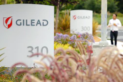 In this July 9, 2015, file photo, a man walks outside the headquarters of Gilead Sciences in Foster City, Calif. Gilead Sciences said Wednesday, March 25, 2020 it will give up the specialty status it received days earlier for its COVID-19 drug amid public outrage that the company was seeking to boost the profits of its treatment.