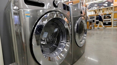 In this Jan. 27, 2020 file photo a clothes washer, left, and dryer, center, are on display at a Home Depot store location, in Boston. Orders to U.S. factories for big-ticket manufactured goods rose by a solid amount in February 2020, but the gain came before the coronavirus had shut down much of the country. The Commerce Department said Wednesday, March 25, durable goods orders rose 1.2% last month, rebounding from January when orders had shown a tiny 0.1% gain.