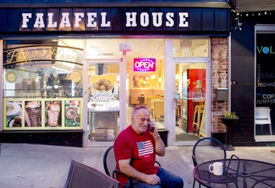 Clade Karim takes a take out order over the phone for Falafel House in downtown Grandin on Monday night, March 30, 2020.
