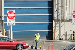 In this April 13 photo, a worker wears a mask as he cleans up an area outside an entrance at Boeing Co.'s airplane assembly facility in Everett, WA, north of Seattle. American industry collapsed in March as the coronavirus pandemic wreaked havoc on the U.S. economy. Manufacturing and overall industrial production posted the biggest drops since the United States demobilized after World War II.