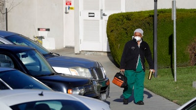 A health care worker leaves Cedar Mountain Post Acute nursing facility in Yucaipa, Calif., Wednesday, April 1, 2020. The Southern California nursing home has been hit hard by the coronavirus, with more than 50 residents infected, a troubling development amid cautious optimism that cases in the state may peak more slowly than expected.