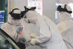 In this March 1, 2020 file photo, medical staff wearing protective suits take samples from a person with suspected symptoms of the new coronavirus at a drive-thru virus test facility in Goyang, South Korea. When the first cases of the disease showed up in South Korea, they reacted quickly with the use of widespread testing, technology to trace at-risk groups, and strict social quarantines and distancing.