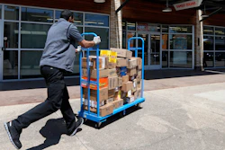 Cameron Webb, an employee with McLane Company, makes a delivery to a Family Dollar in Dallas, Wednesday, April 15, 2020.