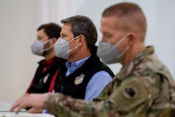 Georgia Gov. Brian Kemp listens to a speaker during a tour of a massive temporary hospital at the Georgia World Congress Center on Thursday, April 16, 2020, in Atlanta.