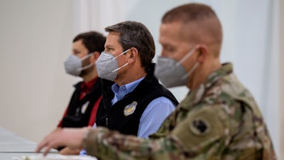 Georgia Gov. Brian Kemp listens to a speaker during a tour of a massive temporary hospital at the Georgia World Congress Center on Thursday, April 16, 2020, in Atlanta.