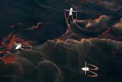 In this May 5, 2010 file photo, shrimp boats are used to collect oil with booms in the waters of Chandeleur Sound, La.