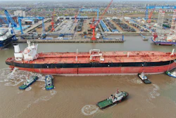 Tugboats push a 300,000-ton very large crude carrier (VLCC) to a shipyard.