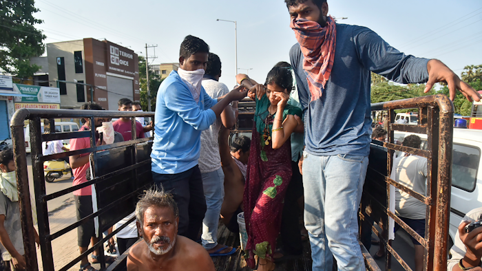 People affected by a chemical gas leak are carried out of a truck to an ambulance in Vishakhapatnam, India.