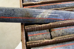 A core sample drilled from underground rock shows a band of shiny minerals.