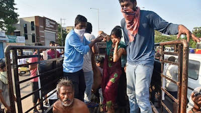 People affected by a chemical gas leak are carried out of a truck to an ambulance in Vishakhapatnam, India.