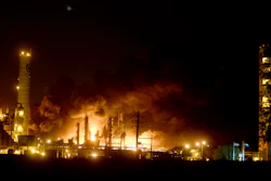 Flames and thick, black smoke light up the pre-dawn sky following an explosion at the TPC plant.