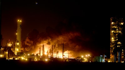 Flames and thick, black smoke light up the pre-dawn sky following an explosion at the TPC plant.