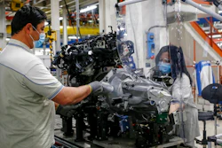 In this April 27, 2020 file photo, a plastic sheet is laid between two workers needing to face each other to perform their task, as a safety measure for coronavirus contamination, at the Fiat Chrysler Automobiles plants of Atessa, in Central Italy. Fiat Chrysler Automobiles has confirmed a request for an Italian state-backed loan to help the sector relaunch from the coronavirus shutdown, a move that set off debate in Italy over whether such money should be made available to companies with legal headquarters overseas.