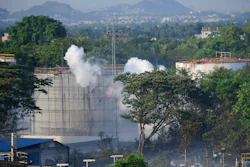 Smoke rises from LG Polymers plant, the site of a chemical gas leakage, in Vishakhapatnam, India, Thursday, May 7, 2020. Synthetic chemical styrene leaked from the industrial plant in southern India early Thursday, leaving people struggling to breathe and collapsing in the streets.