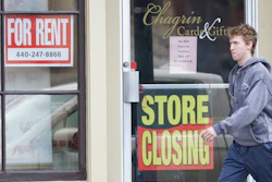 A man walks past a closed business, Wednesday, April 29, 2020, in Chagrin Falls, Ohio. The U.S. economy shrank at a 4.8% annual rate last quarter as the coronavirus pandemic shut down much of the country and began triggering a recession that will end the longest expansion on record.