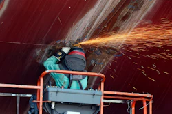 A welder works on the hull of a Zumwalt-class destroyer.