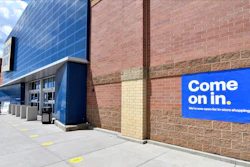 Shoppers, left, head to the entrance as a sign on the outside wall invites customers to shop inside a Best Buy store.